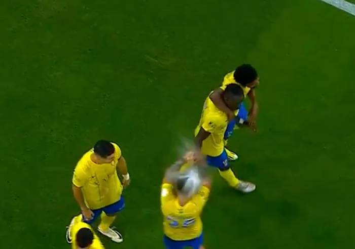 Cristiano Ronaldo pictured (left) standing next to Al Nassr teammate Otavio (center) when the midfielder was struck on the head by a full bottle of water thrown by an Al-Ahli fan during a Saudi Pro League game in March 2024